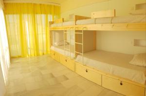 Una habitación con dos literas y suelo de madera. en NEX Hostel, en Nicosia