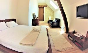 - une chambre avec un lit blanc et une télévision dans l'établissement La Closeraie, à Noyers-sur-Cher