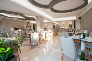 a dining room with tables and chairs in a restaurant at Garden Palace Hotel in Laganas