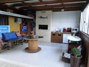 a kitchen and living room with a table in a room at Recanto do Sol Pousada in Capão da Canoa