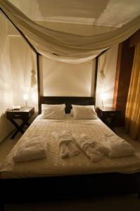 a bedroom with a bed with white sheets and pillows at Riviera Perdika Hotel in Perdika