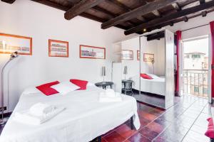a bedroom with a large white bed with red pillows at Romantic house with terrace in Rome