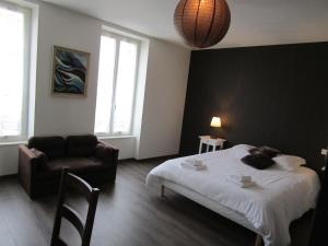 a bedroom with a bed and a chair and a couch at Les Chambres d'Eugénie in Poyanne