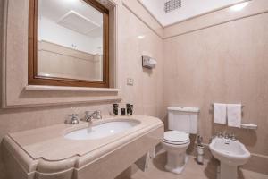 a bathroom with a sink and a toilet and a mirror at Hotel Vittoria in Brescia