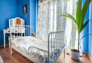 a blue bedroom with a white bed and a plant at Stylish Apartment in Villajoyosa