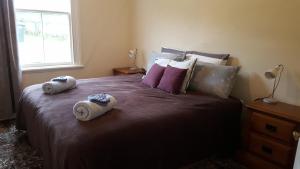 a bedroom with a large bed with towels on it at Central Otago Cottage 4 bedroom in Roxburgh