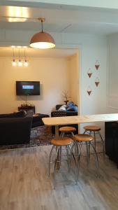 a living room with a table and four stools at Central Otago Cottage 4 bedroom in Roxburgh