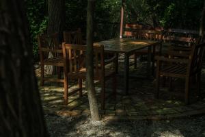 a wooden table and chairs in the woods at Enpi Lake Resort in Iaşi
