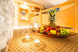 uma taça de fruta sentada num balcão com velas em Hotel Verena em Lana