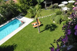 una piscina en un patio con una palmera y un banco en Hotel Verena, en Lana