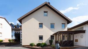 una casa bianca con tetto marrone di Gästezimmer - Ferienwohnung 1 - Brauhaus Dürr a Dorfprozelten