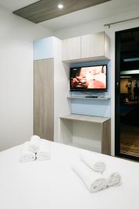een kamer met een televisie en een bed met witte lakens bij Illyria in Skradin