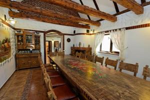 una sala da pranzo con un grande tavolo in legno e sedie di Vila Ambient a Cristian