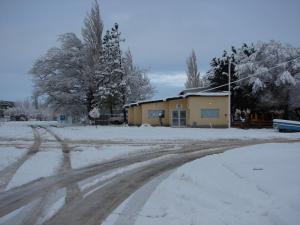 una carretera cubierta de nieve frente a una casa en Hospedaje "San Andres", en Gobernador Gregores