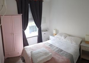 a bedroom with a bed and a window at The Coach House in Plymouth