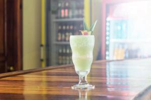 a drink in a glass sitting on a table at Hotel Delfin Playa Bejuco in Esterillos Este