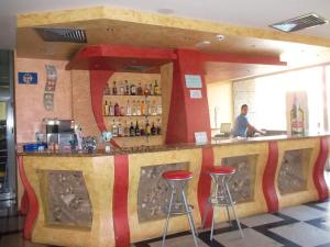 a bar in a restaurant with two stools at Hotel Kamenec in Kiten
