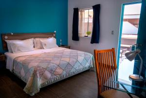 1 dormitorio con cama y pared azul en Hotel Villa Jazmin en Ica