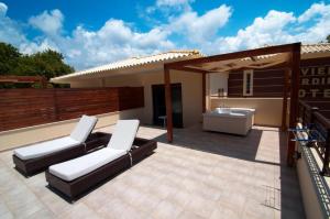 a patio with two white chairs and a sink at Riviera Perdika Hotel in Perdika