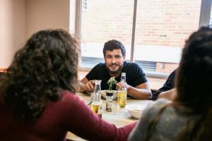 a man sitting at a table with a group of people at Barkly Backpackers in Melbourne