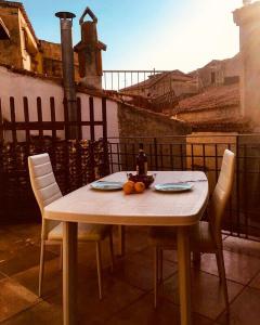 una mesa con sillas y una botella de vino y fruta. en Scalea Historic Center Apartments en Scalea