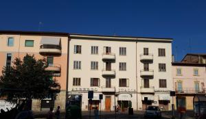 a large white building with balconies on a street at Albergo Italia di Nardi Renzo & C Snc in Poggibonsi