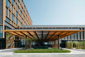 a large building with a wooden canopy in front of it at Artyzen Habitat Hongqiao Shanghai - Korean Street in Shanghai