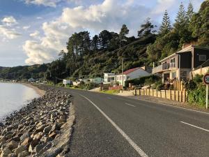 un camino junto a un río con casas en él en Te Mata Bay Seaviews, en Tapu