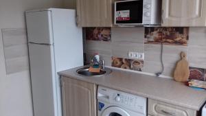 una cucina con frigorifero bianco e lavastoviglie di Apartment on Rusanivska 16 a Kiev