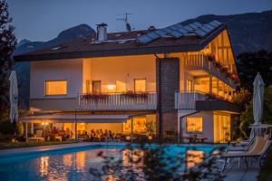 a large house with a swimming pool in front of it at Hotel Sonnenhof in Lana