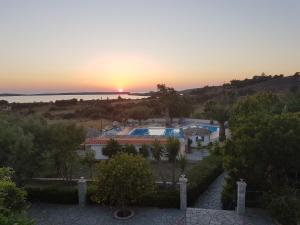 um pôr-do-sol sobre um resort com piscina em Orama Hotel em Sígrion
