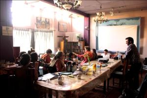 a group of people sitting around a long table at Sahi River View Guest house in Varanasi
