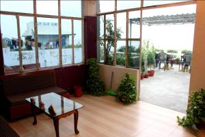 バラナシにあるSahi River View Guest houseのソファ、テーブル、窓が備わる客室です。
