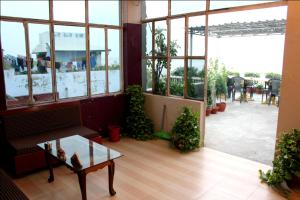 a room with a couch and a table and windows at Sahi River View Guest house in Varanasi