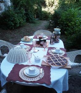 B&B La Locanda Di Cavoleto في Piandimeleto: طاولة عليها قماش الطاولة البيضاء والطعام