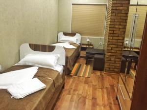 a room with three beds and a brick wall at Zarya Hotel in Khorog