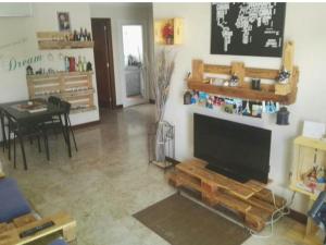 a living room with a flat screen tv on a wall at Papá Totë in Playa Honda