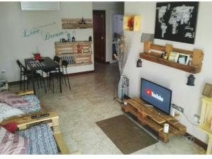 uma sala de estar com uma televisão de ecrã plano e uma sala de jantar em Papá Totë em Playa Honda