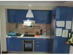 a blue kitchen with a sink and a refrigerator at Papá Totë in Playa Honda