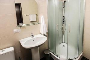 a bathroom with a shower, sink, and toilet at Shelter Hotel in Kyiv