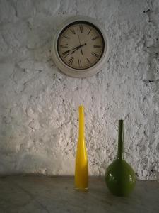dos jarrones sentados en una mesa con un reloj en la pared en Patio De La Luna, en Asilah