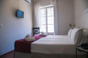 a bedroom with a large white bed with towels on it at Hostal Callejon del Agua in Seville
