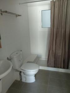 a white bathroom with a toilet and a sink at Apartaments Can Fabul in Sant Carles de la Ràpita