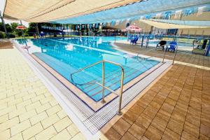 uma grande piscina com água azul em Amiad Joseph Well Country Inn em Ammiad