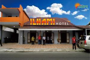 un hôtel avec des personnes debout à l'extérieur dans l'établissement Hotel Ilhami Blitar, à Blitar