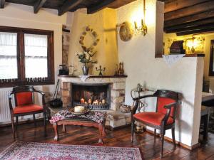 a living room with two chairs and a fireplace at To Archontiko Guesthouse Villa in Stavroupoli