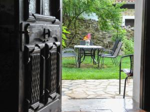 Une porte ouverte s'ouvre sur une terrasse avec une table et des chaises. dans l'établissement To Archontiko Guesthouse Villa, à Stavroúpoli