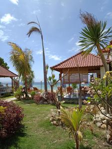 a resort with palm trees and the ocean in the background at The Umah Prahu in Nusa Penida