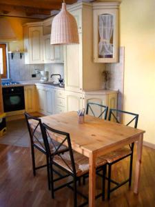 una cucina con tavolo in legno e 4 sedie di B&B1913 a Monte Libretti