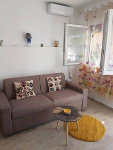 a living room with a brown couch and a table at Studio in Tivat